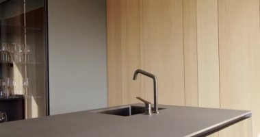 Yeni moda mobilyalarla dolu güzel bir mutfak. Bir adası olan lüks bir mutfak. Minimalist bir mutfağın içinde. Mutfağın içi çok şık. Modern Açık Konsept Ev İçi.