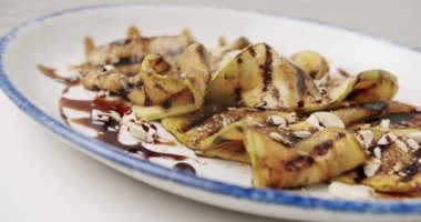 Kızarmış patlıcan. Dönen beyaz tabakta fındıklı lezzetli sebzeler. Izgara restoran yemeği. Kızarmış patlıcan. Patlıcan kızartmasının yakın çekimi..