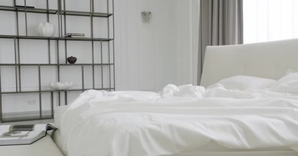 モダンなホテルベッドルーム多くの枕とインテリアとダブルベッド 内部のミニマリズムのスカンディナヴィアスタイル ホワイトキングサイズベッド付きのベッドルーム ミニマリストの白いベッドルームとエレガンスインテリアデザイン — ストック動画