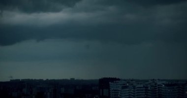 Zaman ayarlı gökyüzü ve şehirde kara bulut. Koyu gri fırtına bulutları. Dramatik bir gökyüzü. Kara fırtınalı bulutlarda aydınlatma. Kara fırtına bulutları hızlı hareket ediyor. Yağmurlu küresel ısınma etkisi siyah gök gürültülü fırtına.