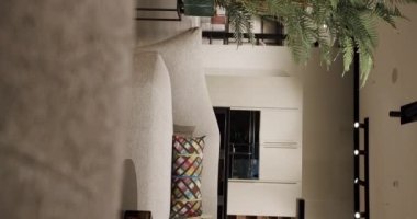 Beyaz mobilyalı modern Minimalist oturma odası. Köşedeki kanepe, sandalye, kitaplık ve mutfak odalı lüks Modern Ev İçi. Samimi Modern Mobilya Tasarımı. Dikey video.