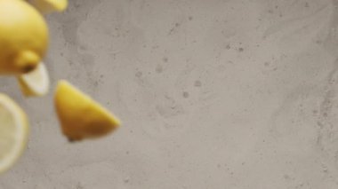 Limon dilimleri kesilmiş bir sürü limon havada çarpışır ve kumun üzerine düşer. Limonata yaz içkisi için yaratıcı bir vuruş. Doğal dilimlenmiş limon.