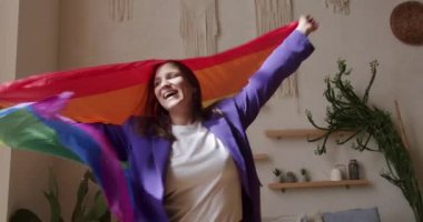 Mutlu lezbiyen kadınlar evde dinleniyor. İyi eğlenceler, LGBT bayrağıyla dans edin. Aşk LGBTQI, Gurur Etkinliği, LGBT Gurur Ayı, arkadaşlık konsepti. LGBT hakları, yaşam tarzı ve ilişkiler. LGBT kavramı.
