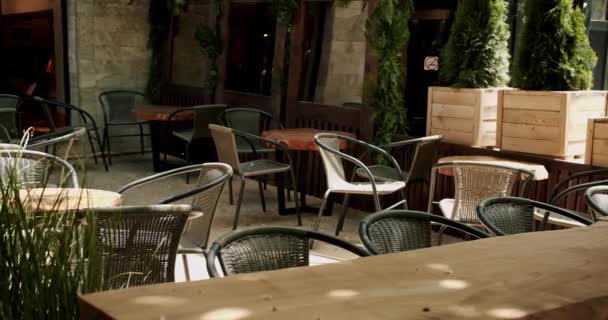 通りのカフェで黒い現代的なシャリーを持つ木製のテーブル 夏の朝の空のカフェ モダンな屋外カフェ ストリートカフェ 現代のテラス 空のレストラン — ストック動画