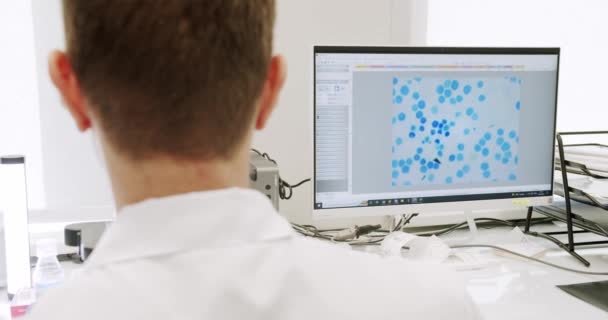Laboratuvar Önlüklü Lateks Eldivenli Bir Adam Gündüz Klinikte Çalışırken Mikroskop — Stok video
