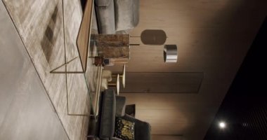 Gri mobilyaları ve tahta duvarları olan modern Minimalist oturma odası. Köşedeki kanepe, sandalye ve kitaplığı olan lüks modern ev içi. Gayrimenkul özel evi. Dikey video.