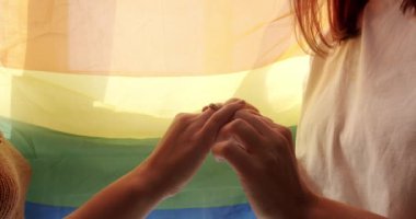 Mutlu lezbiyen çift. Aşk, lezbiyen çift eğleniyor. Kız sevgilisinin eline nişan yüzüğünü takıyordu, Lgbt bayrağında romantik bir kutlamanın tadını çıkarıyordu. LGBT hakları, lezbiyen ailesi.