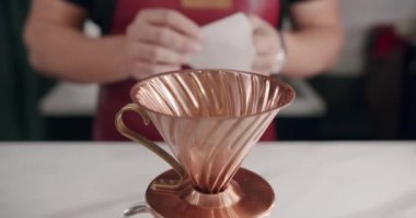 Önlüklü tanınmayan bir erkek barista modern kafede kahve hazırlarken çaydanlıktan fincana su dolduruyor. Kahve yapıyorum. Barista kahve hazırlıyor. Latte hazırlama.