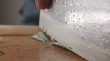 Genç aşçının ahşap bir tahtanın üzerinde bıçakla ince dilimler halinde yeşil soğan kestiği ön manzara. Mutfakta çalışan genç bir aşçının ön görüntüsü. Büyük mutfak bıçağı. Pirzola doğruyor.