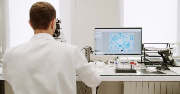 Mężczyzna Lekarz Pomocą Mikroskopu Laboratorium Mężczyzna Fartuchu Laboratoryjnym Rękawiczkach Lateksowych — Wideo stockowe