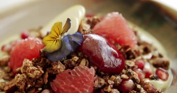 碗里塞满了松果 黄芙蓉和酸奶 慢动作旋转 与格拉诺拉谷物健康的早餐 味道鲜美的麦片靠近点 — 图库视频影像