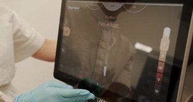 Doktor ellerinin kapatılması prosedürden önce lazer cihazını çalıştırır, Güzellik Uzmanı lazer tüy temizleme cihazını ayarlar. Doktor güzellik prosedürünü seçiyor. Teçhizat görüntüsü.