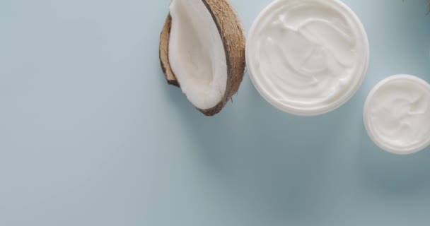 Białe Butelki Tuby Kokosem Kosmetyków Obracających Się Jasnoniebieskim Tle Studio — Wideo stockowe
