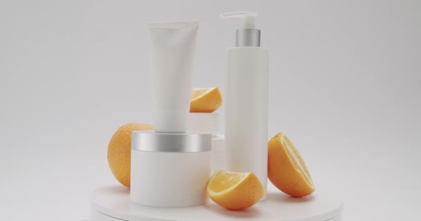 化妆品用油是以天然成分 洗涤剂 护肤为基础的 用于头发和皮肤护理的化妆品生产 白底美容处理用的装有橙色水果的瓶子和管子 — 图库视频影像
