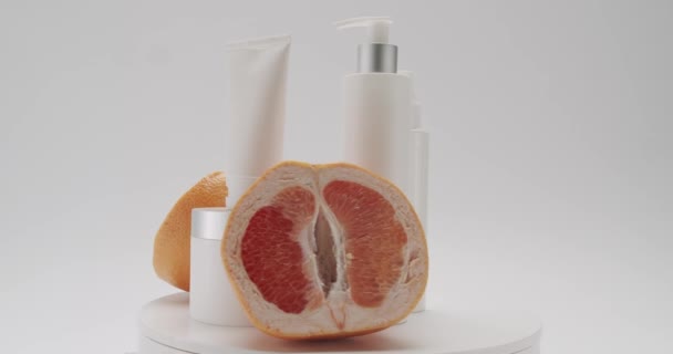 Bílé Láhve Trubice Grapefruitem Otočit Pro Kosmetiku Bílém Pozadí Studiu — Stock video