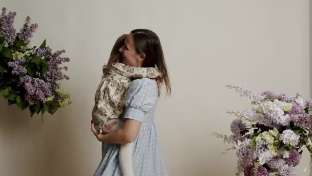 Portret Matki Miłością Obejmującej Córkę Białym Tle Kwiatami Studio Beztroskie — Wideo stockowe