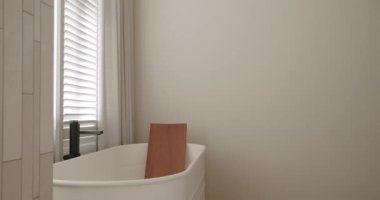 Lüks Banyo İçi, banyo aksesuarları, ayna ve duş başlığı, modern iç mekanda yuvarlak ayna, banyo küveti modern tasarımı olan minimalist iç mimari. Lüks, rahat, beyaz bir daire..