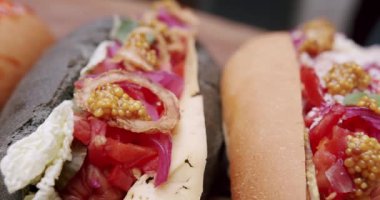 İştah açıcı sosisli sandviç. Ev yapımı sosisli sandviç, hardal ve ketçap, salata ve havuç, domates, zeytin, soğan, salatalık. Ve bir sürü malzeme. Büyük şehirde sokak yemekleri.
