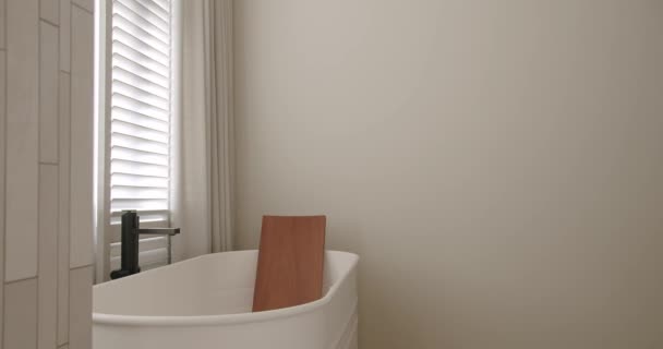 豪華なバスルームインテリア バスルームの付属品 ミラーとシャワーヘッド モダンなインテリアのラウンドミラー バスタブ現代的なデザインで白の色でミニマリストのインテリア 高級居心地の良い白いアパート — ストック動画