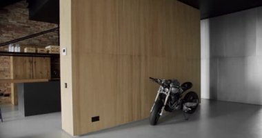 Lüks Modern Ev İçi. Minimalist İç İşleri. Samimi Modern Mobilya Tasarımı. Lüks Zarif Oda. Modern Minimalist oturma odası ahşap duvarlı ve spor motosikletli.