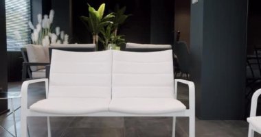 Minimalist sandalyesi ve masası olan beyaz teras mobilyası. Bahçe mobilyaları, Modern Lüks Villa. Minimalist daire. Açık masa ve bahçe parkı için sandalyeler. Lüks villa için modern sandalyeler.