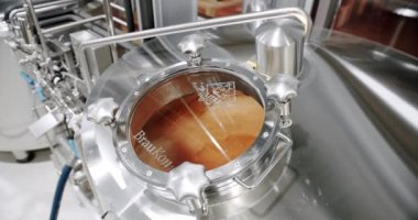 Bira üretimi malt tanelerini bira fabrikasındaki büyük bir öğütme tankına döküyor. Modern bira fabrikası. Bira yapmak için kocaman çelik tanklar. El yapımı bira fabrikası, içinde bira olan çaydanlık..