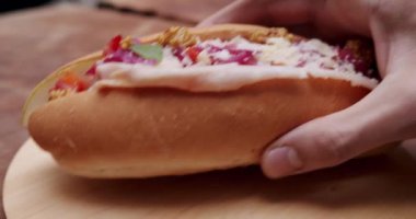 Ev yapımı sosisli sandviç, hardal, ketçap, salata, havuç ve bir sürü malzeme. Büyük şehirde sokak yemeği. İştah açıcı sosisli sandviç..