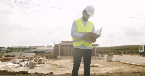 Man Ingenieur Uniform Witte Helm Maakt Notities Notitieboekje Het Werk — Stockvideo