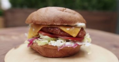 Lezzetli hamburger yemeye hazır. Lezzetli fast food konsepti. Yakın plan. Köfteli hamburger, domates, salatalık, marul. Etli büyük iştah açıcı burger..