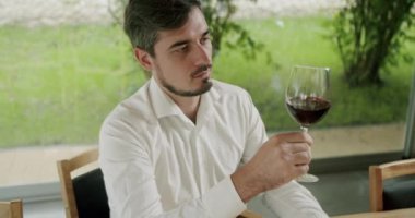 Camların dönüşü şarabın yüzeyini dalgalandırıyor ve uzun cam duvarlar boyunca uzanıyor. Sommelier şarap kadehini sallıyor ve tadına bakıyor..