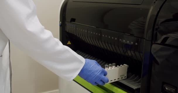 コンピューター機器を使った血液検査 血液検査機は実験室でサンプルをチェックします 作業プロセス中の自動機械 バイオラボ医療クリニック化学自動分析装置 — ストック動画