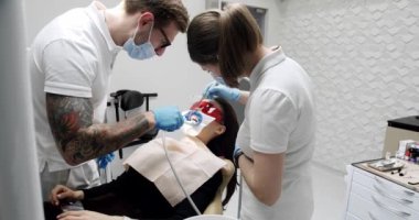 Dentist making tooth cleaning for patient in dental modern clinic. Modern dental clinic. Female patient at hygiene teeth cleaning procedure in dentistry. Teeth Cleaning Ultrasonic Scaling.