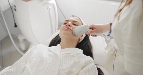 専門の美容師は 女性患者と美容室で顔の手順を行います 顔の皮膚の機械的治療プロセスのクローズアップ 化粧品技術革新 — ストック動画