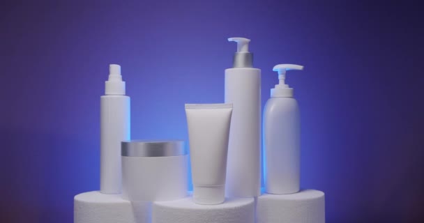 Статичний Знімок Біла Пляшка Трубки Косметики Синьому Фоні Студії Світло — стокове відео