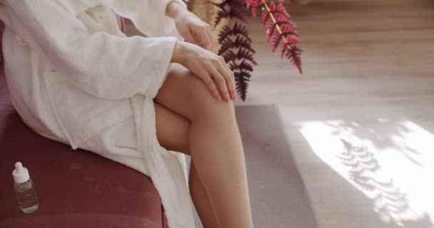 女人在腿上涂润肤霜和按摩 天然美容产品 矿物油 生态化妆品霜 妇女应用血清 抗衰老或发亮的皮肤 — 图库视频影像