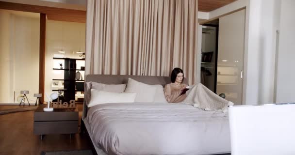 Mujer Relajándose Cama Leyendo Libro Dormitorio Casa Moderna Una Hermosa — Vídeo de stock
