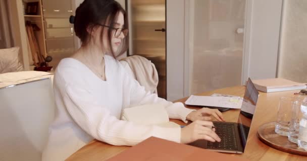 デスクトップPcで働く眼鏡の若い女性に焦点を当てた 自宅のオフィスでコンピューターの仕事をしている若いビジネスマン 彼女の成功を保証するために懸命に働いている オフィスのインテリアで働く若いビジネス女性 — ストック動画
