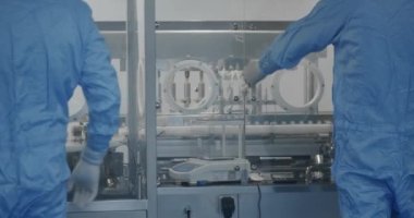 Fabrika Temizlik Odası. İlaç, Biyoteknoloji ve Yarı iletken Üretim Süreci. Steril Koruyucu Giysilerdeki Bilim adamları Modern Laboratuvar Üzerinde Çalışıyor.