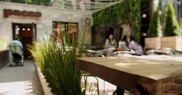 通りのカフェで黒い現代的なシャリーを持つ木製のテーブル 夏の朝の空のカフェ モダンな屋外カフェ ストリートカフェ 現代のテラス 空のレストラン — ストック動画