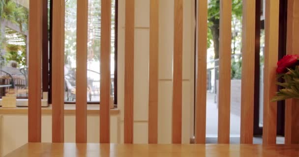 木製インテリアのモダンなレストランカフェ 木製のライン 木製のスラットの壁 顧客を受け取るための木製のカウンター 木製の椅子とテーブルを備えたモダンなミニマリストカフェ — ストック動画