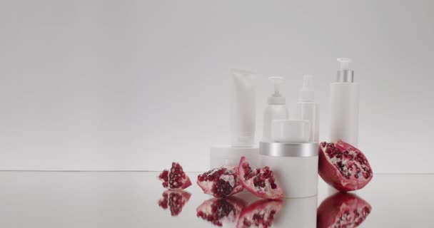 Weiße Flasche Und Tuben Mit Granatapfelfrüchten Für Kosmetik Auf Weißem — Stockvideo