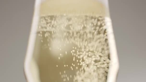 低角度的无法辨认的人倒入淡雅的水晶杯子 白色背景 白色背景下的香槟香槟泡沫 — 图库视频影像