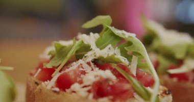 Delicious bruschetta sourdough toast with cherry tomatoes, cheese and arugula. Traditional italian breakfast brunch dish at a restaurant, Healthy food and dieting concept. Italian Bruschetta crostini.