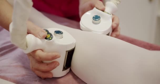 Zbliżenie Ręce Profesjonalnej Masażystki Wykonującej Kobiecy Masaż Pacjenta Nodze Maszyną — Wideo stockowe