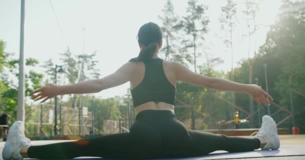 Rückenansicht Einer Athletischen Frau Aktivkleidung Die Beinspalten Auf Einer Trainingsmatte — Stockvideo