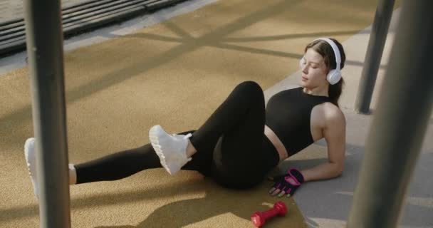 Kulaklıklı Atletik Bir Kadın Müzik Dinliyor Dışarıda Egzersiz Yapıyor Yalan — Stok video