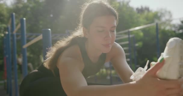 Csinos Sportszerkóban Tornacipőben Sportfelszereléssel Gyakorol Nyújtja Lábát Szabadban Edzőtéren Fiatal — Stock videók