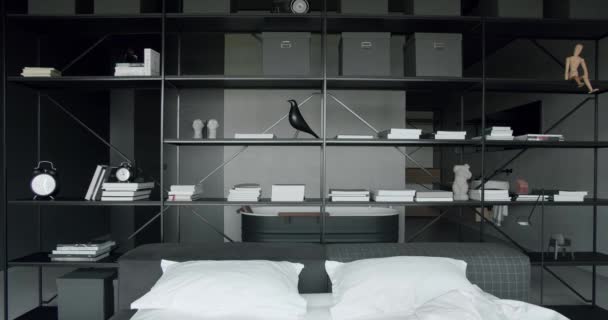 黒と白のインテリアデザイン モダンなベッドルームのインテリアとベッドには枕がたくさんあります インテリアの最小限のスカンジナビアスタイル 壁に本棚が付いている内部 — ストック動画