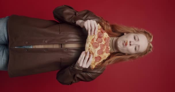 Pionowe Wideo Piękna Głodna Dziewczyna Brązowej Koszuli Jedząc Pizzę Pepperoni — Wideo stockowe