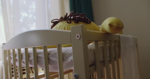 保育室の保護境界を有する木製ベビーベッド 柔らかいおもちゃと寝具が付いている現代ベビーベッド 新生児を期待し 子供部屋を準備する — ストック動画